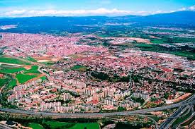 Fontanero Barberà del Vallès en una calle céntrica con edificios modernos y montañas al fondo