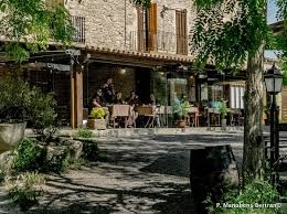 Fontanero Callús frente a una calle estrecha con edificios de piedra y tejados rojos en el centro histórico de Callús