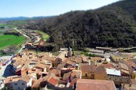 Fontanero Castellfollit de Riubregós reparando tuberías en calle típica con casas de piedra y flores en balcones