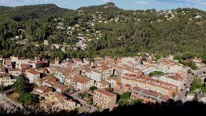Fontanero Castellví de Rosanes trabajando en una calle pintoresca con casas tradicionales y montañas al fondo