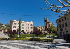 Fontanero Dosrius reparando tuberías cerca del emblemático puente medieval sobre el río Riera en una calle céntrica.