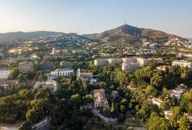 Fontanero Esplugues de Llobregat calle con edificios modernos y fontanero trabajando en tuberías urbanas