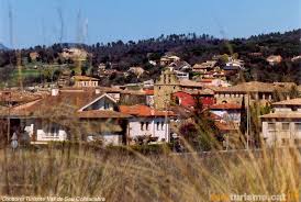 Calle de Folgueroles con fontanero trabajando, herramientas y paisaje urbano típico, consulta Fontanero Folgueroles
