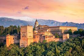 Fontanero La Granada reparando tubería en calle empedrada, fondo de casas blancas y montañas al atardecer