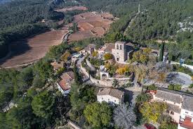 Fontanero Olivella: vista de calles empedradas con casas de campo tradicionales en un entorno pintoresco rural.