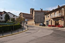 Fontanero Olvan: vista de calle tranquila con casas de piedra y paisaje montañoso al fondo, típica de Olvan.