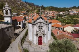 Fontanero Perafita: calle de Perafita con casas tradicionales y fontanería en acción, vecino caminando por la acera.