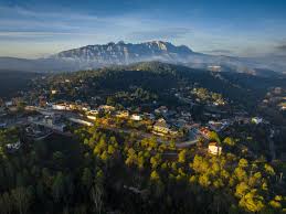Taller de fontanería en una calle de Rellinars con casas típicas y montaña al fondo Fontanero Rellinars