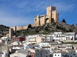 Fontanero Rubió calle estrecha adoquinada con casas de piedra y flores en balcones, típico de esta ciudad.