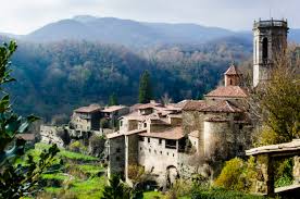 Fontanero Rupit i Pruit calle empedrada con casas de piedra y montañas fondo en el encantador pueblo medieval