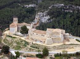 Fontanero San Martín Sarroca en calle pintoresca con arquitectura medieval y paisaje montañoso al fondo