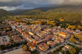 Fontanero Sant Esteve de Palautordera en calle típica con casas de piedra y montaña al fondo
