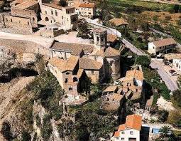 Fontanero Sant Martí Sarroca frente al castillo medieval, rodeado de calles empedradas y arquitectura histórica.