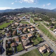 Fontanero Sant Pere de Vilamajor arreglando tuberías en calle adoquinada con casas típicas del pueblo.