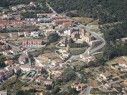 Fontanero Santa Eulàlia de Ronçana en calle tranquila con casas tradicionales y colinas verdes al fondo.