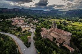 Fontanero Vilanova de Sau calle pintoresca con casas rústicas y montaña de fondo en el casco urbano de la ciudad